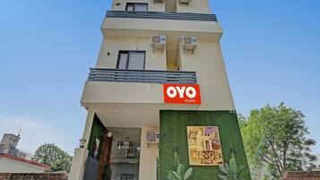 Un edificio con un letrero que dice 'OYO Rooms' y un letrero que dice 'Kings' en la entrada.