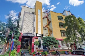 A hotel with a prominent spiral staircase, a sign for 'HOTEL ALPINE', and a 'YO' logo. - Hotel O ASA AGRA (Agra)