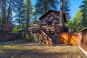 A wooden cabin with a deck and stairs, surrounded by trees. - Hot Tub + Pine-View Decks • Near Speedboat Beach + Crystal Bay | Emberpine (Kings Beach)