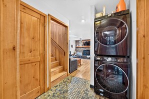 A laundry room with a double-door entry, a washing machine, and a dryer. - Hot Tub + Pine-View Decks • Near Speedboat Beach + Crystal Bay | Emberpine (Kings Beach)