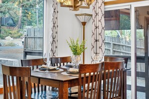 A dining table set for six with a vase of greenery, surrounded by wooden chairs. - Hot Tub + Pine-View Decks • Near Speedboat Beach + Crystal Bay | Emberpine (Kings Beach)