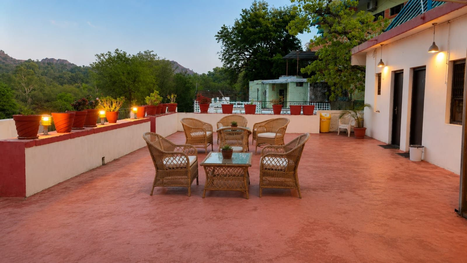 Une terrasse extérieure aménagée avec des meubles en osier et des plantes en pot.