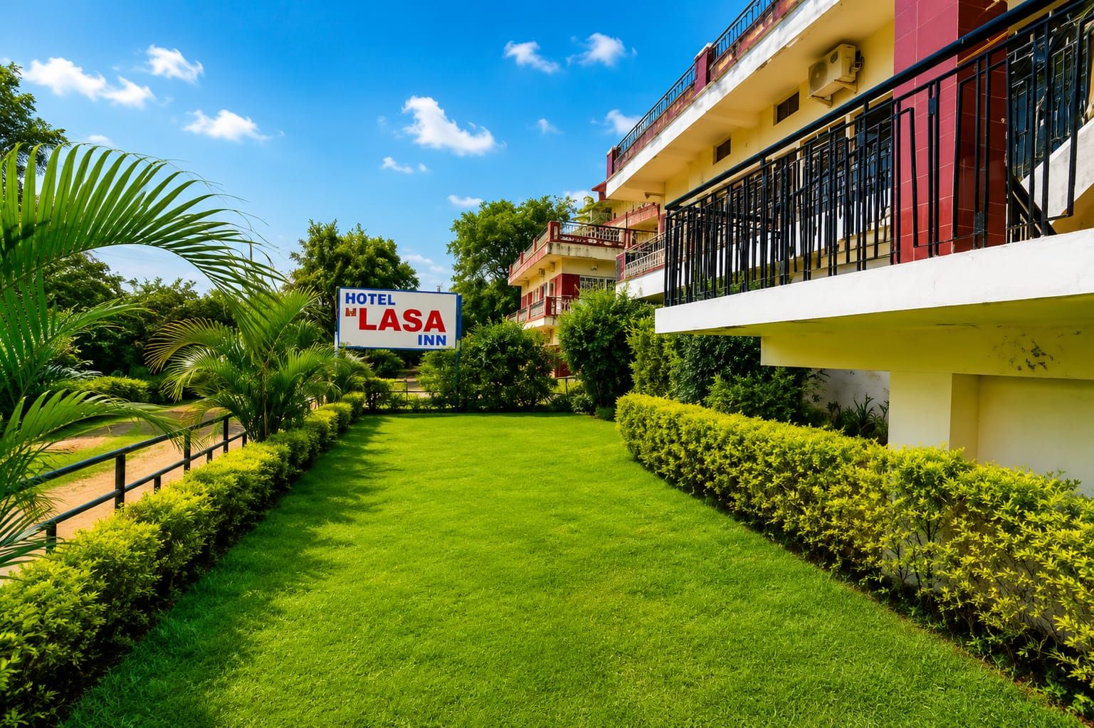 Un hôtel appelé « Lasa Inn », doté d’une pelouse bien entretenue, d’une enseigne et d’un bâtiment avec des balcons.