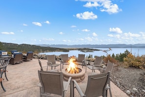 An outdoor seating area with a fire pit and chairs overlooking a lake. - Lakeview Retreat 4BR Home (Somers)