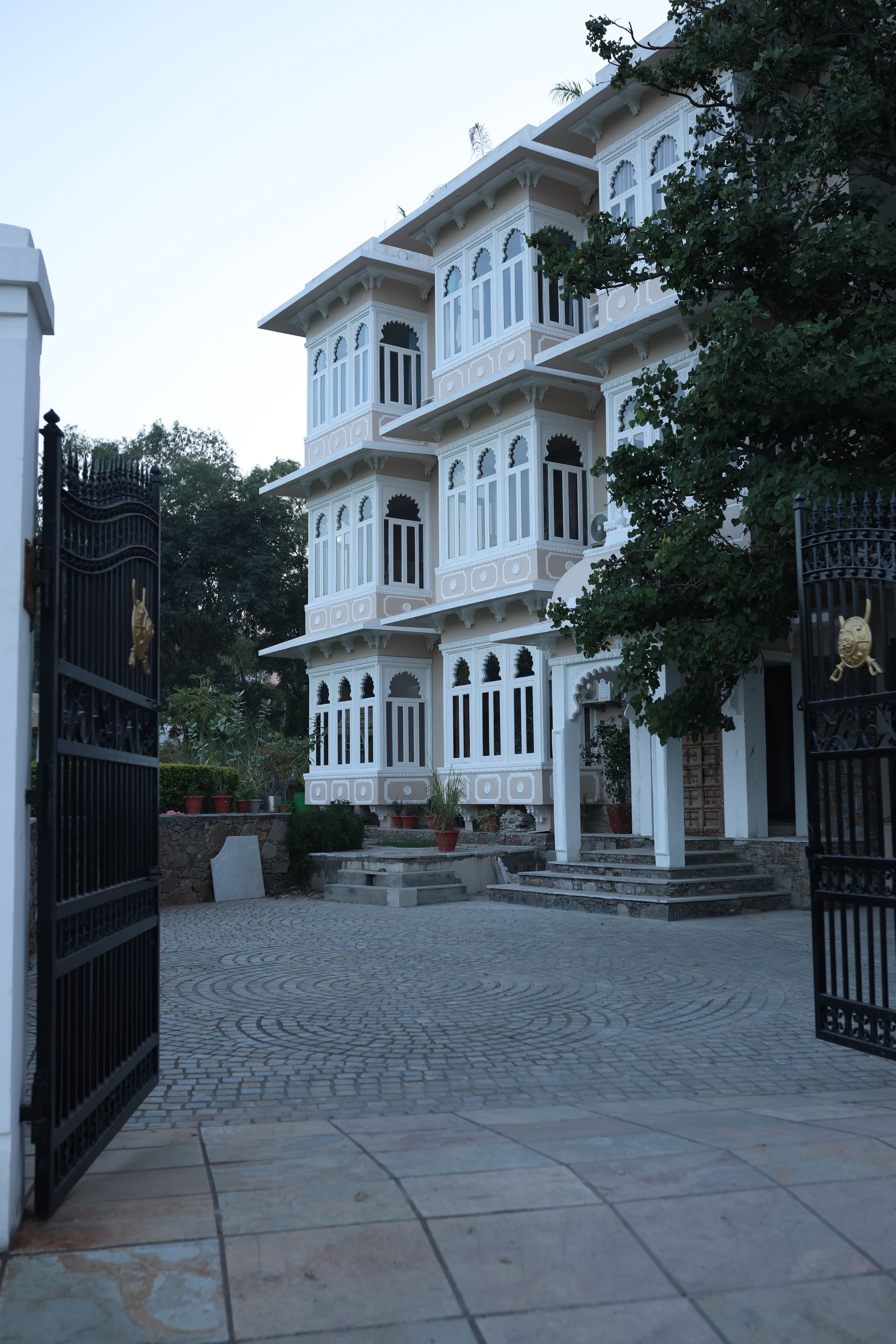 Ein mehrstöckiges Gebäude im traditionellen Baustil, mit aufwendigen Balkonen und einem Innenhof mit einem Kopfsteinpflasterweg.