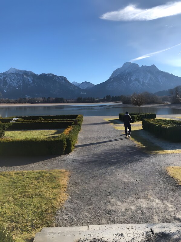 A pathway leading to a lake with mountains in the background.