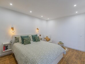 A modern bedroom with a large bed, bedside tables, and a nightstand. - CHL La Palma Beach Infront of the sea (Santa Cruz de la Palma)
