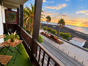 A balcony with a view of the sea and a street lined with palm trees and plants. - CHL La Palma Beach Infront of the sea (Santa Cruz de la Palma)