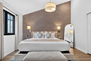 A modern bedroom with a large bed, two bedside lamps, a mirror, and a window with curtains. - Cal King Studio | Paso Market | Walk to City Park + Fairgrounds | The Tulip Tree (Paso Robles)