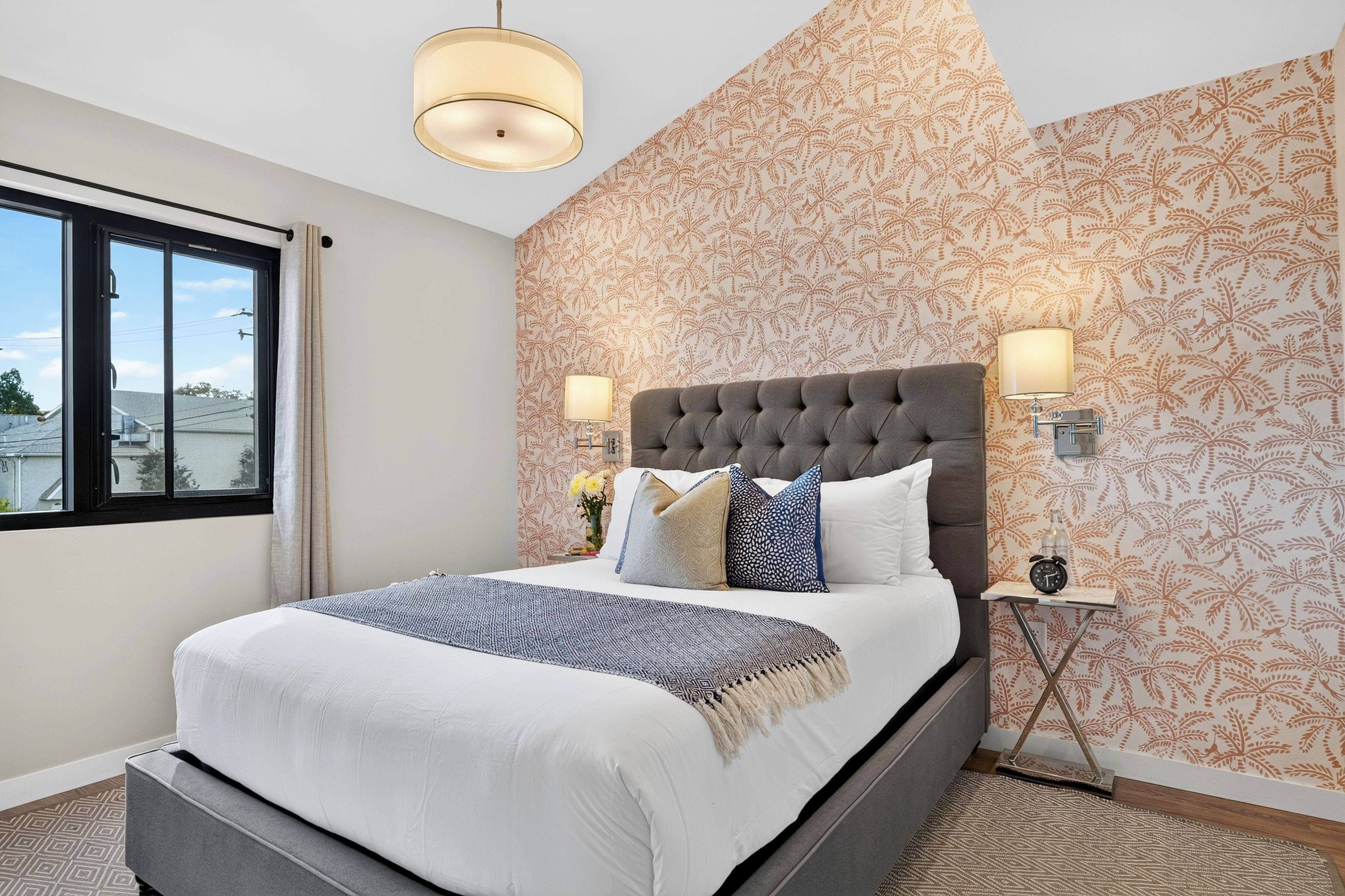 The Rosewood Room studio: Rest easy in the queen bed with a palm-print accent wall and soft, welcoming light.