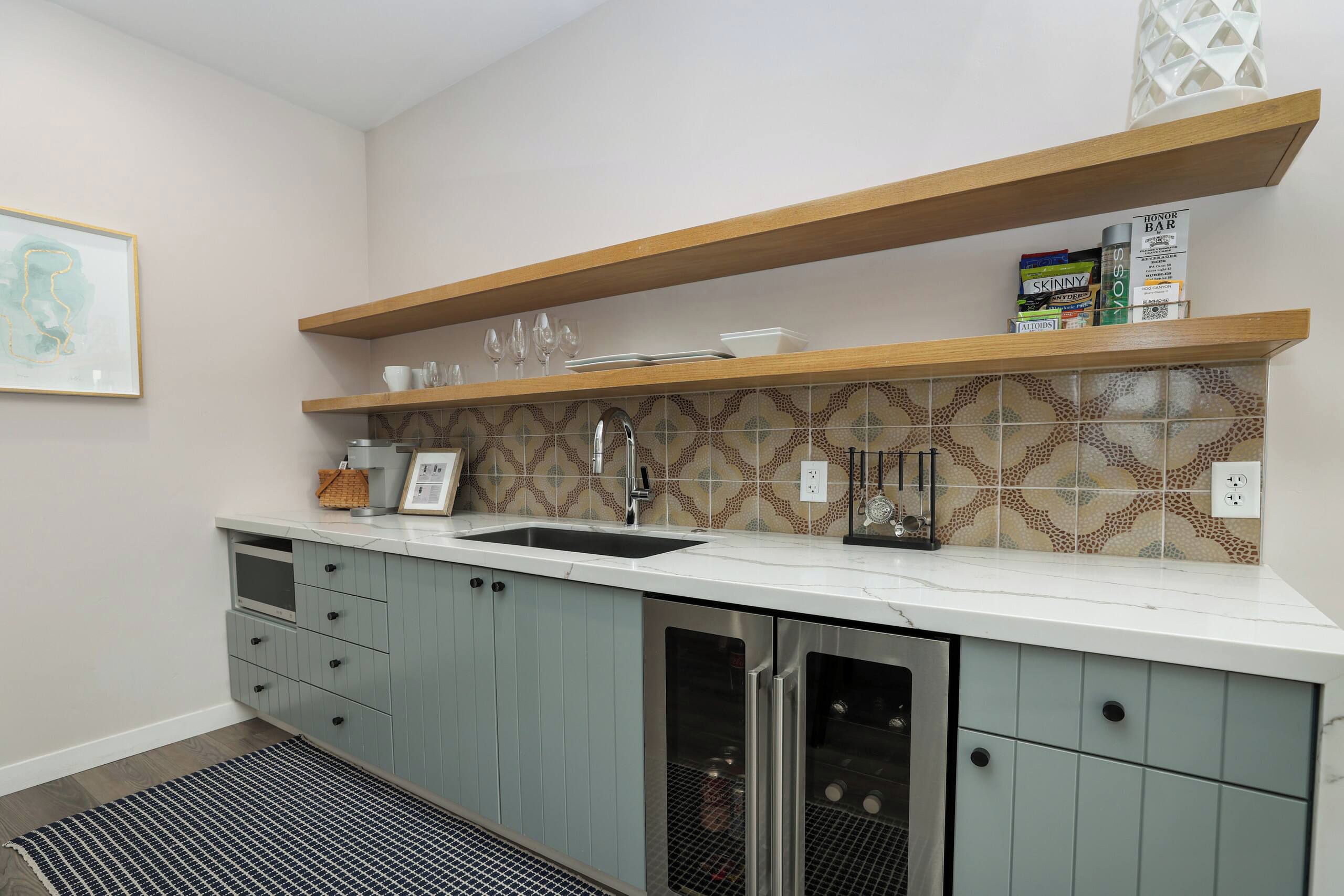 Una cocina con lavavajillas incorporado, un lavabo y una estantería para vinos en la encimera.