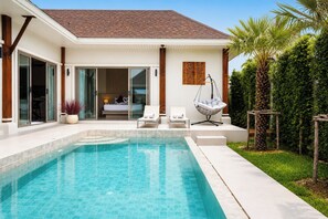 Una casa moderna con piscina, un dormitorio con puerta corredera y un jardín con palmeras.