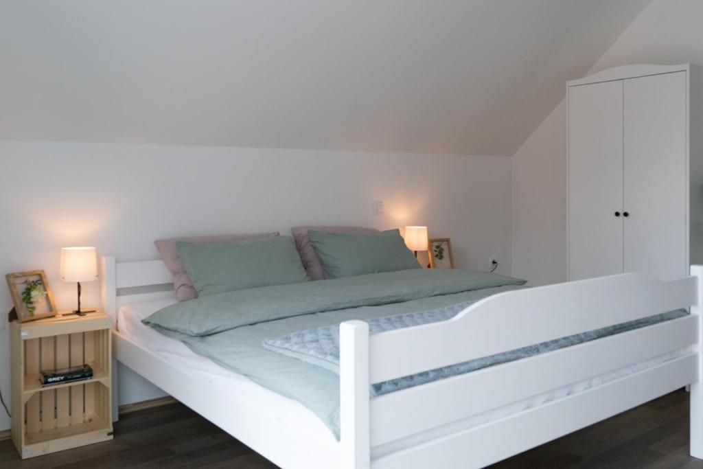 Habitación individual con una cama de una sola plaza, cabecera blanca, mesita de noche con lámpara y armario.