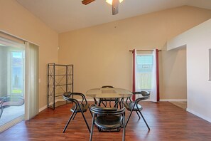 A room with a dining table and chairs, a ceiling fan, and a view through a door. - Travel Nurses Welcome! Zephyrhills Extended Stay (Zephyrhills)