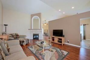 A living room with a fireplace, a television, and a seating area with sofas and a coffee table. - Travel Nurses Welcome! Zephyrhills Extended Stay (Zephyrhills)