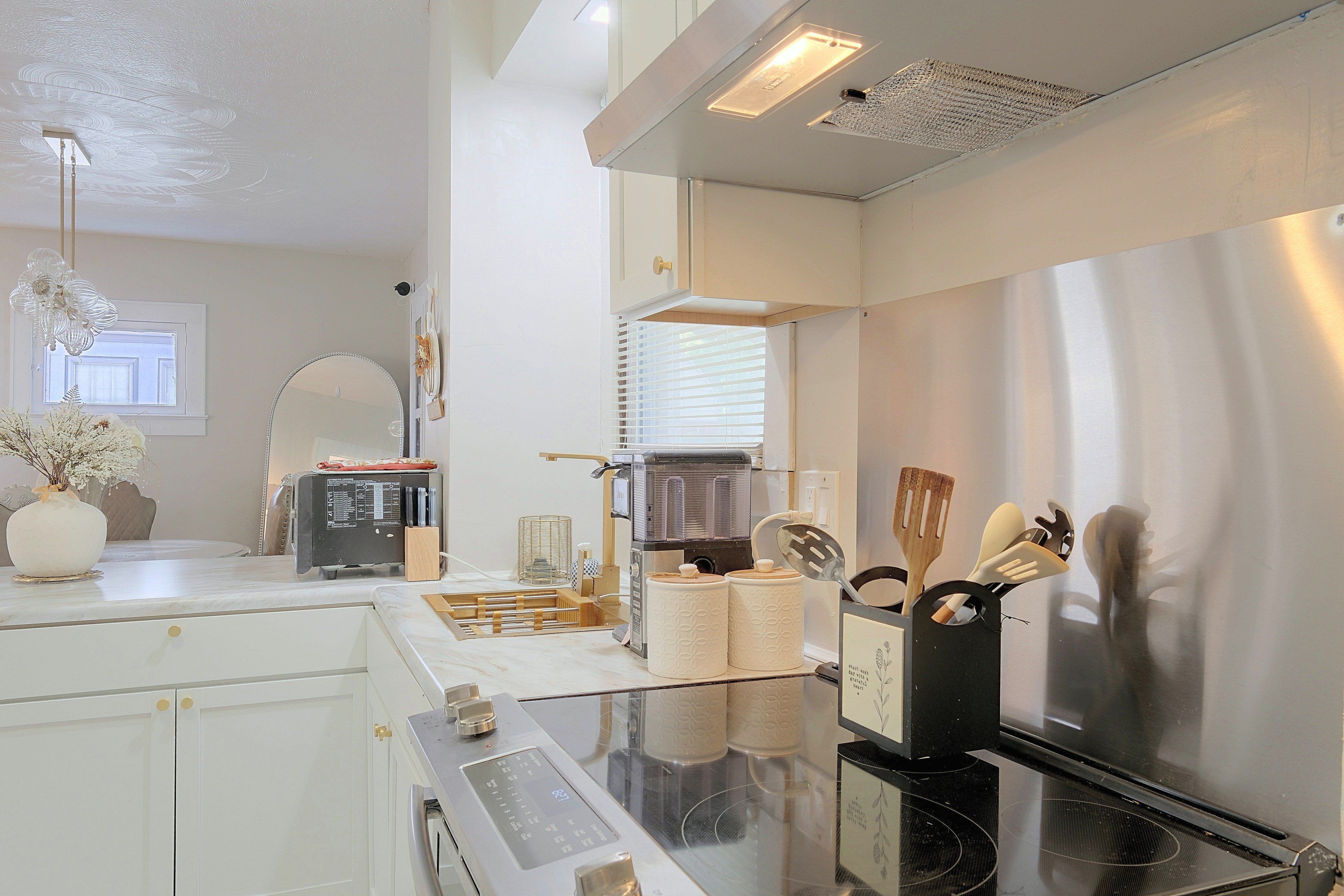 A modern kitchen with a built-in oven, a coffee machine, and a glass-top dining table.