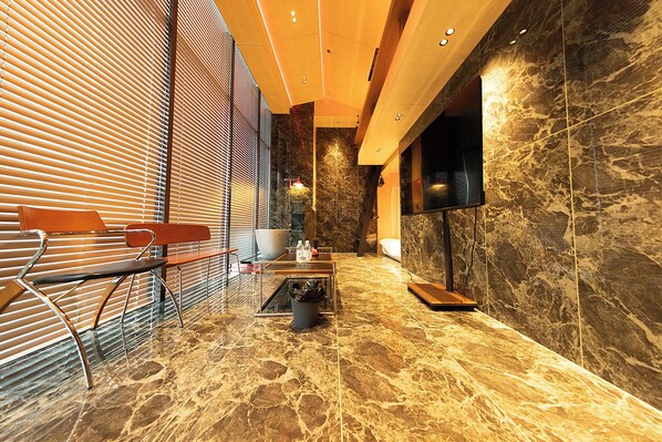 A modern interior with a seating area, a large white bowl, and a television on a wall. - X Hotel (Tongzhou)