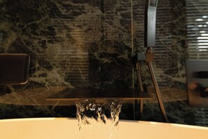 A bathroom with a marble wall, a sink, and a mirror. - X Hotel (Tongzhou)