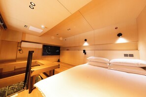 A hotel room with a bed, a desk, a television, and a ceiling with recessed lighting. - X Hotel (Tongzhou)