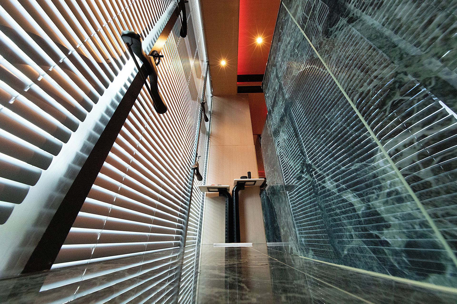 A corridor with patterned walls, a reflective floor, and a red ceiling.