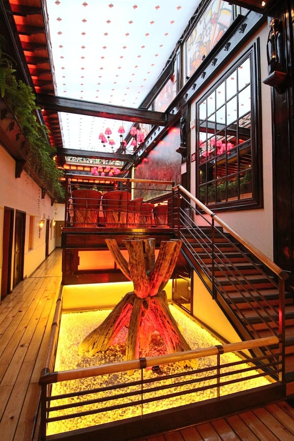 A multi-level interior with a central wooden structure, a staircase, and a glass ceiling. - Hotel Parque Mexico - Petit (Mexico City)