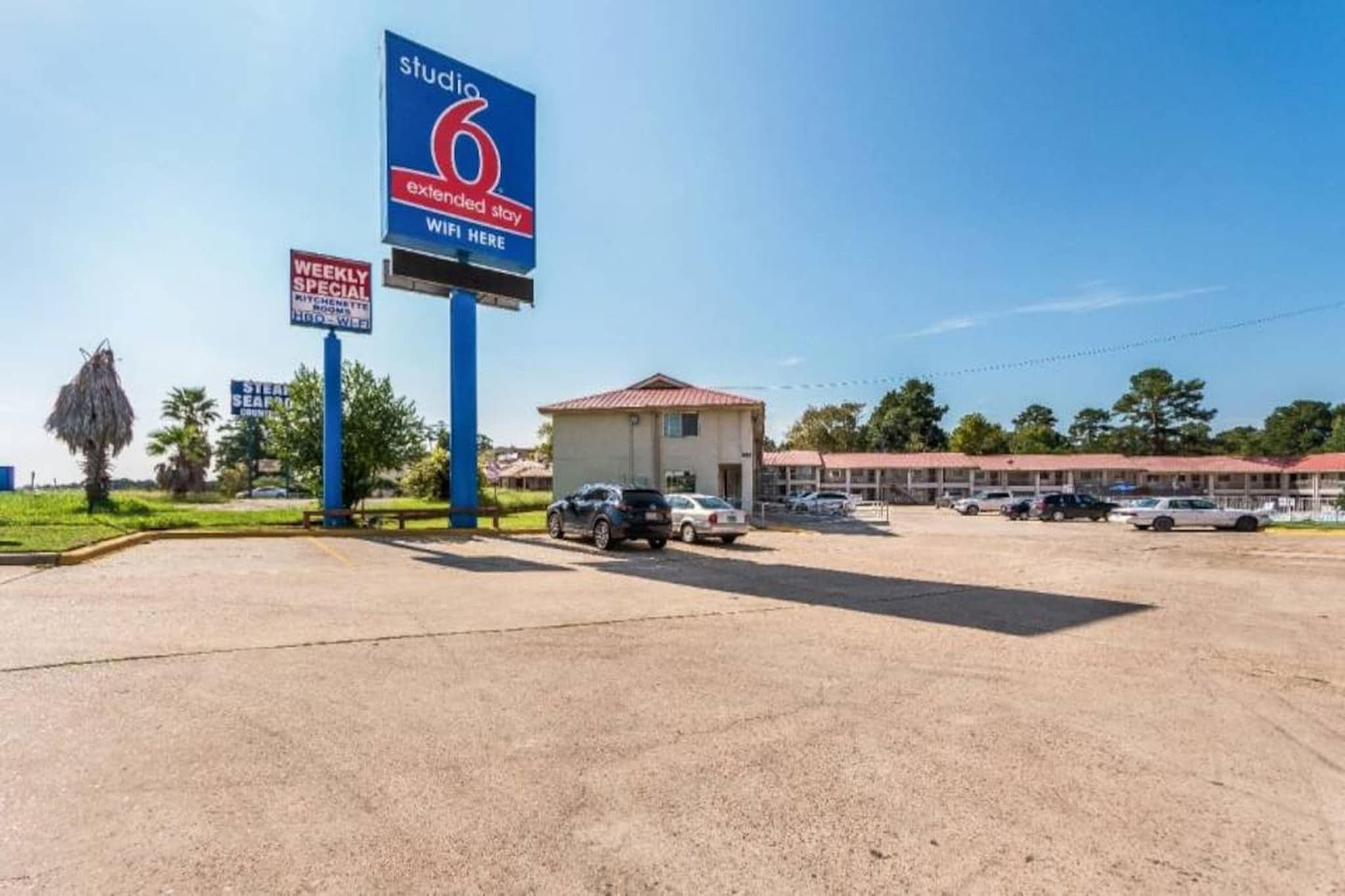 A motel with a sign indicating extended stay and WiFi availability.