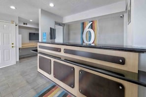 A reception desk with a number '6' sign, a flat-screen TV, and a security camera. - 2 Queen Beds | Non-Smoking, Kitchen (Dallas)