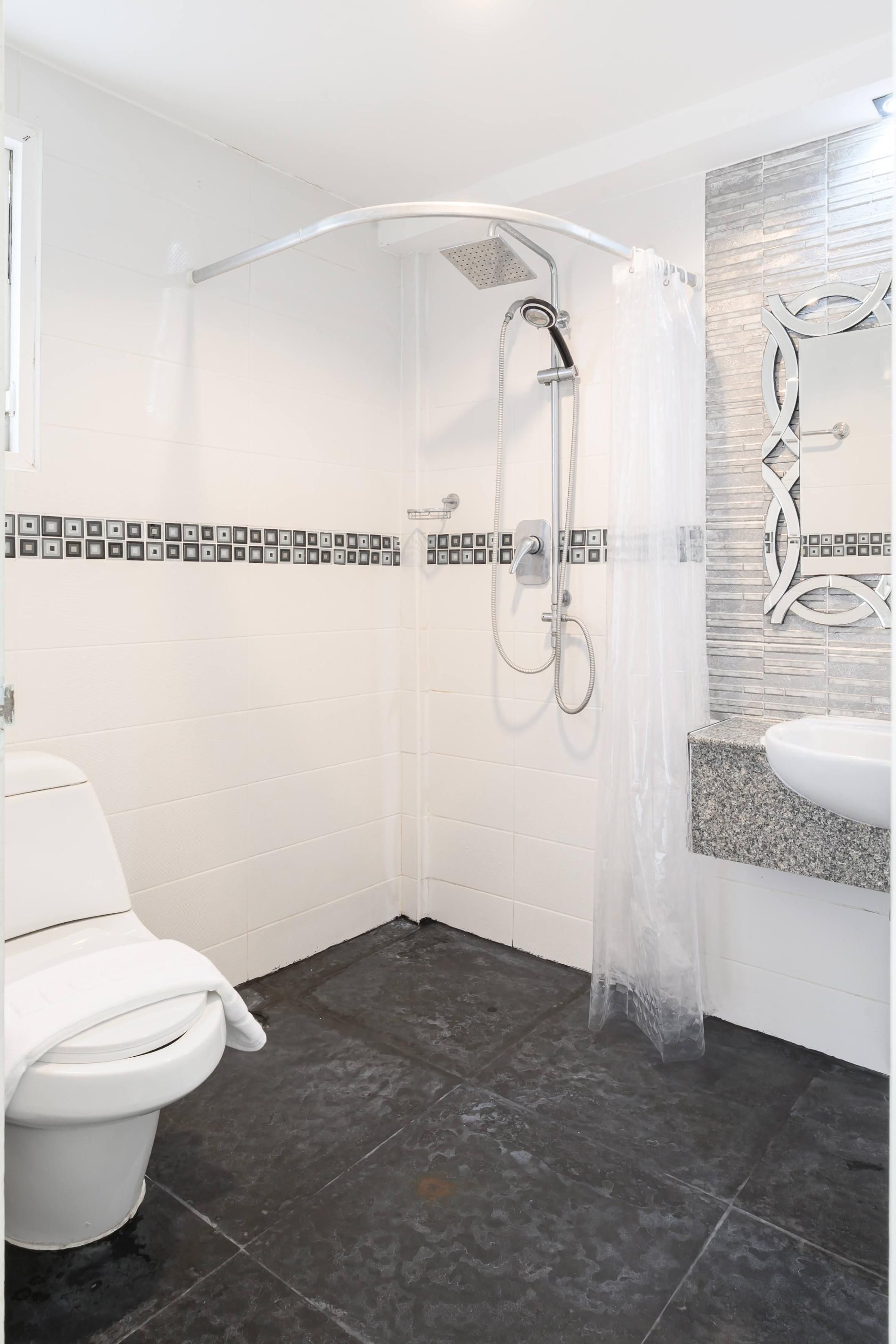 A modern bathroom with a shower, toilet, and sink.