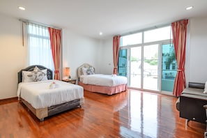 A hotel room with two beds, a desk, and a large sliding glass door to the outside. - Wongamat 3BR Townhouse near Beach (NP1) (Bang Lamung,)