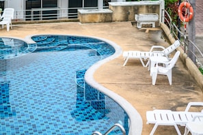 A swimming pool with a tiled edge, surrounded by white plastic chairs and a lifebuoy on a concrete deck. - Wongamat 3BR Townhouse near Beach (NP1) (Bang Lamung,)