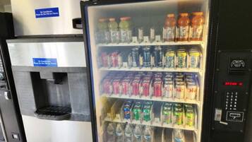 En automattankstation med ett stort utbud av drycker, inklusive läsk och vatten.
