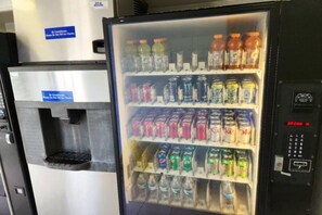 Un distributeur automatique proposant une variété de boissons, notamment des sodas et de l’eau.