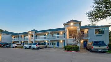 A multi-story hotel with a parking lot.