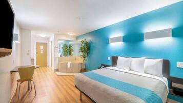 Une chambre d’hôtel avec un lit, un bureau et une chaise.