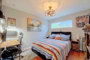 A bedroom with a bed, a desk, a chair, a window, and a ceiling light fixture. - Walkable West 6th Condo w/ Pool & Porch (Austin)