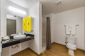 A bathroom with a sink, mirror, toilet, and shower curtain. - 1 King Bed|NS| Kitchen (New Braunfels)