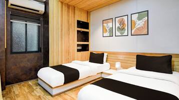 A hotel room with two beds, a wooden ceiling, and artwork on the wall.