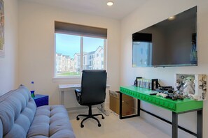 A room with a desk, a chair, a couch, and a window with blinds. - Spacious & Modern Springs Home w/ Mtn Views (Colorado Springs)