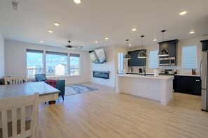 A modern kitchen with a central island, built-in appliances, and large windows. - Spacious & Modern Springs Home w/ Mtn Views (Colorado Springs)