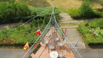 A suspension bridge with outdoor seating and flags.