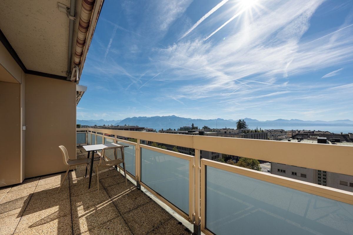 A balcony with a view of distant mountains and a cityscape.