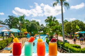 A poolside view with colorful drinks and a tropical setting. - New Listing in Legacy Dunes! Updated 2 Bdrm,1 bath Condo | Minutes to Disney, Gated Community w Pool (Kissimmee)