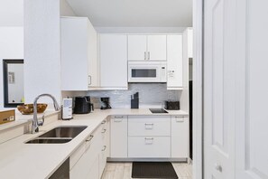 Bright kitchen with Microwave, 2 burner cooktop, dishwasher and refrigerator (no oven) - New Listing in Legacy Dunes! Updated 2 Bdrm,1 bath Condo | Minutes to Disney, Gated Community w Pool (Kissimmee)