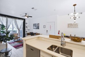 A modern kitchen with a built-in sink, a ceiling fan, and a dining area with a table and chairs. - New Listing in Legacy Dunes! Updated 2 Bdrm,1 bath Condo | Minutes to Disney, Gated Community w Pool (Kissimmee)