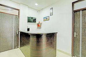 A reception desk with a glass top, two security cameras, and a framed picture on the wall. - Hotel O Solam Inn (Lucknow)