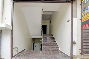 Una escalera conduce a una habitación con techo y paredes blancos, y se observa una puerta al final. Un letrero indica el lugar como 'Solam Inn'.