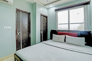 A bedroom with a bed, two doors, a window, and a power outlet. - Hotel O Solam Inn (Lucknow)