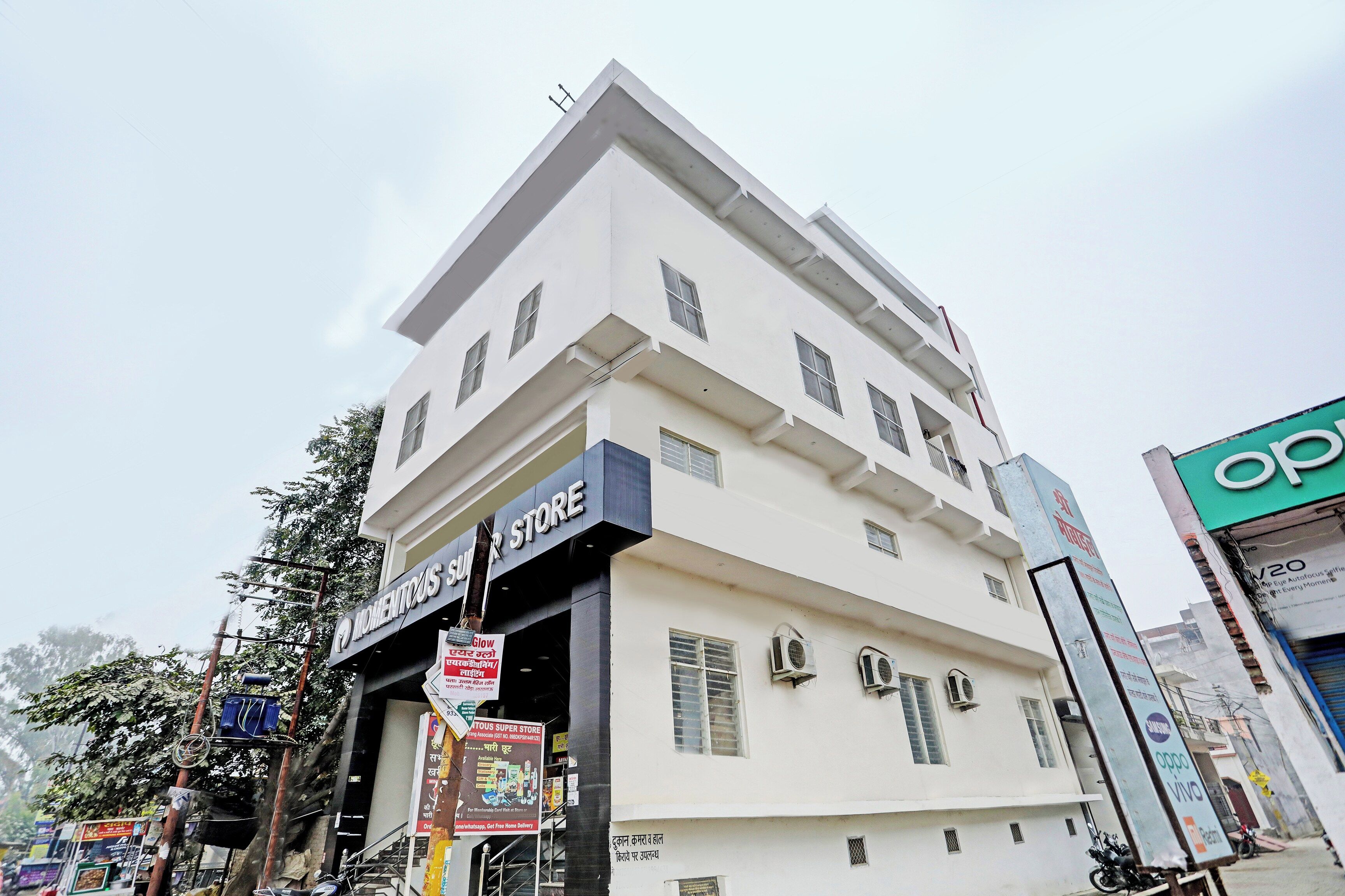 Un immeuble à plusieurs étages sur lequel on peut voir une grande enseigne indiquant « MOMENTOUS SUPER STORE ».