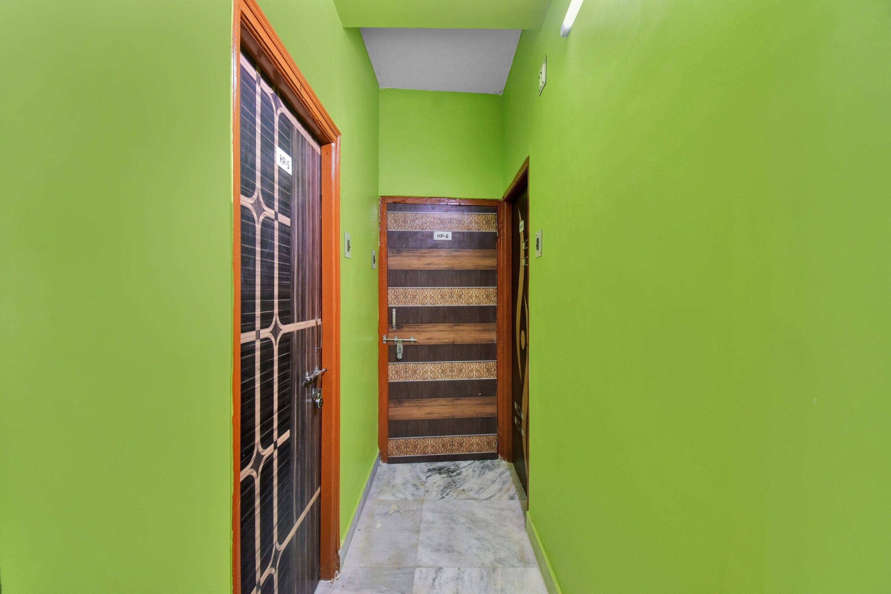 A narrow hallway with green walls and a wooden door labeled 'HP-6'.