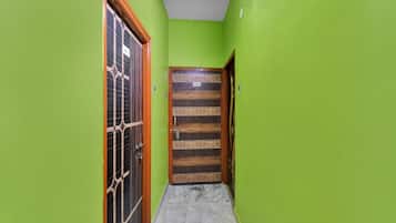 A narrow hallway with green walls and a wooden door labeled 'HP-6'.